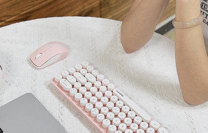 MOFII Bean 2.4G 1200 DPI wireless optical mouse in pink next to compact keyboard on desk
